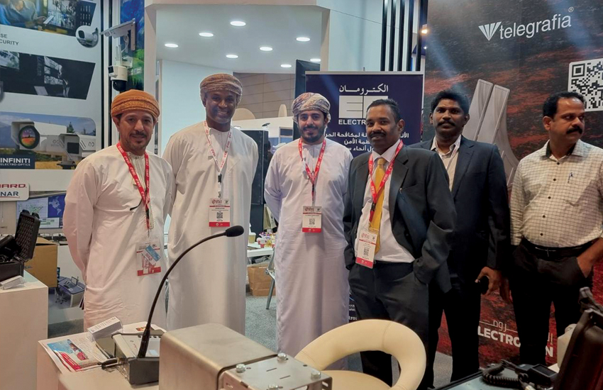 Команда Electroman Oman на стенде выставки OFSEC 2025, представляющая решения в области безопасности и оповещения.
